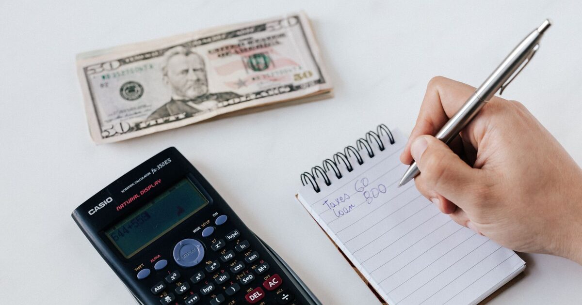 A calculator, home documents, and keys representing estimating the cost of home ownership