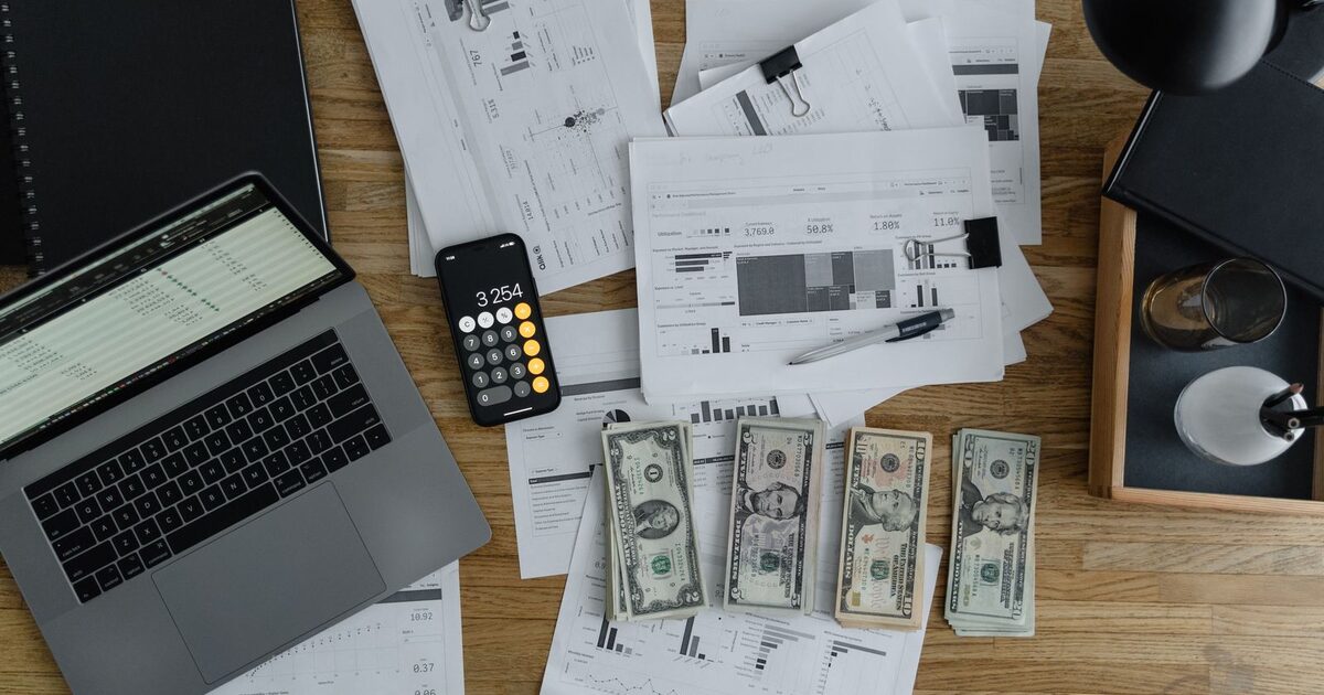 Home documents and a calculator representing comparing a home warranty to a maintenance fund